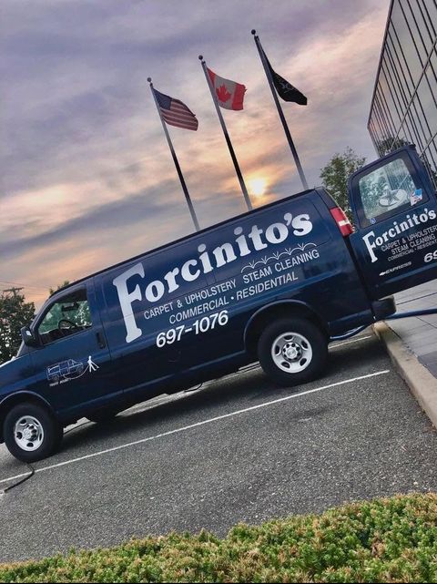 The Forcinito’s van parked beneath three flags at dusk